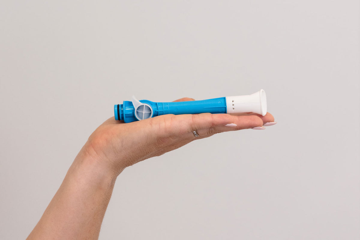 A hand holding a blue and white dental device against a solid light gray background. #Product_Aero® HVE Wide Mouth (Belmont, DentalEz & Forest) #Product_Aero® HVE Wide Mouth (Aspetico, DCI Comfort, Engle, Marus, Midmark, Peloton & Crane & Royal) #Product_Aero® HVE Wide Mouth (A-dec) 