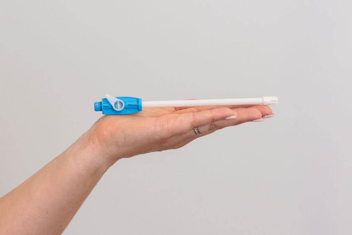 A hand holding a dental device against a plain light gray background. #Product_SE Plus Valve #Color_Blue